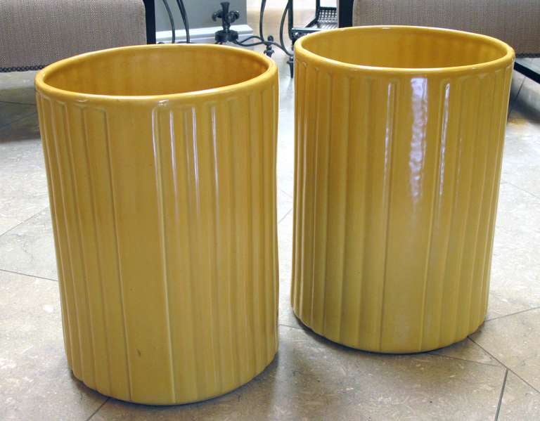 A large-scaled pair of American 1940's golden-yellow glazed ceramic umbrella jars; designer Harold Holman, Alamo Pottery, San Antonio, Texas; each large ribbed jar of cylindrical form decorated in a soft yellow glaze over white clay; with impressed