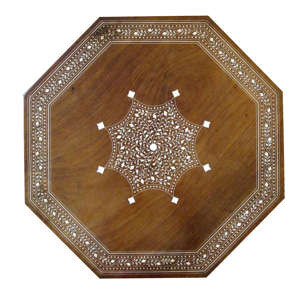 A handsome and intricately inlaid Anglo-Indian octagonal traveling table; the octagonal top centering an inlaid medallion within a foliate band; raised on arabesque supports