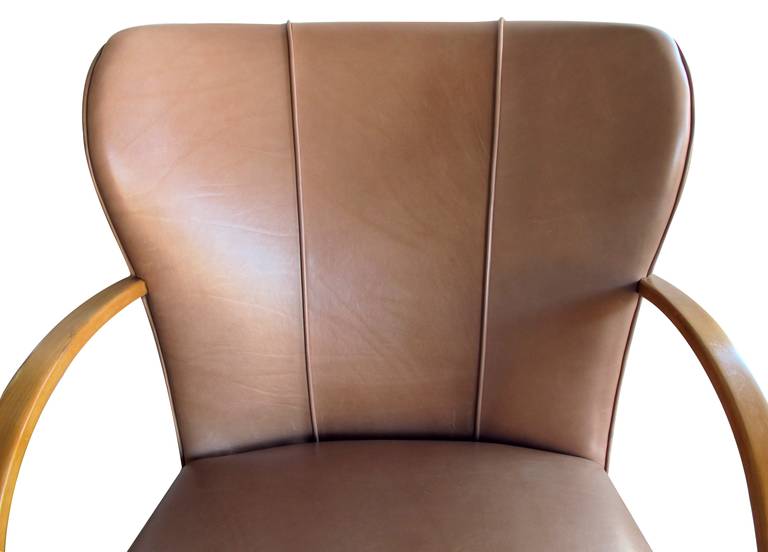 A large-scaled pair of Swedish 1940's wing back chairs with bentwood arms; each with large padded incurved backs above a tight seat flanked by bentwood arms raised on splayed supports; new taupe leather upholstery