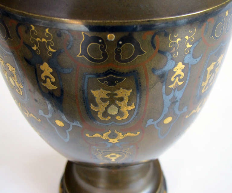 A good quality pair of Japanese bronze urns with brass and pewter inlay now mounted as lamps; Gump's, San Francisco; each heavy and well-patinated urn with flaring neck above an void body; with brass and pewter inlay of fanciful creatures amid