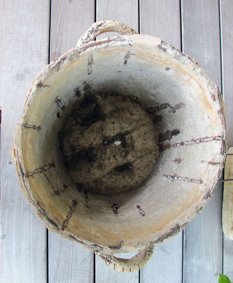 A whimsical French faux bois concrete double-handled jardiniere; of conical form flanked by loop handles raised on 3 looped feet; decorated with a well-textured faux bois surface of simulated bark