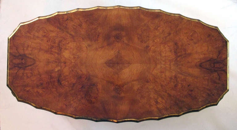A good quality English art deco burl maple cocktail table with scalloped apron; by H & L Epstein Furniture Co., England; for a similar example see Miller's Furniture: World Styles from Classical to Contemporary pg. 413; the oval-shaped top of