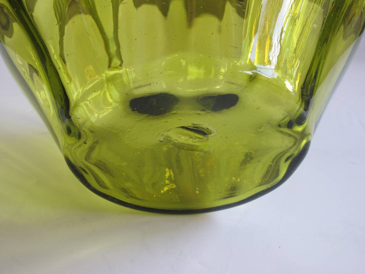 A grandly-scaled American Mid-Century acid-green art glass 'optic' pitcher; designed by Wayne Husted for Blenko Glass, 1953; the over-scaled ewer comprised of optic panels with applied reeded handle and soft pontil mark on underside.