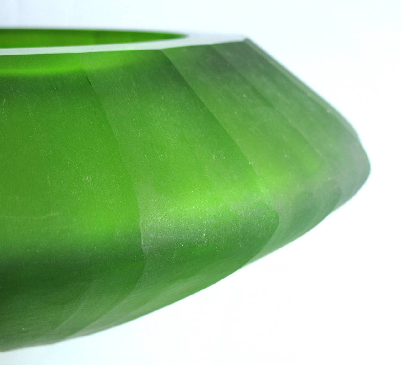 A thickly modeled Bohemian art deco apple-green elliptical bowl of frosted faceted glass; possibly Moser Glass Works; the squat bowl of frosted glass tapering to the foot