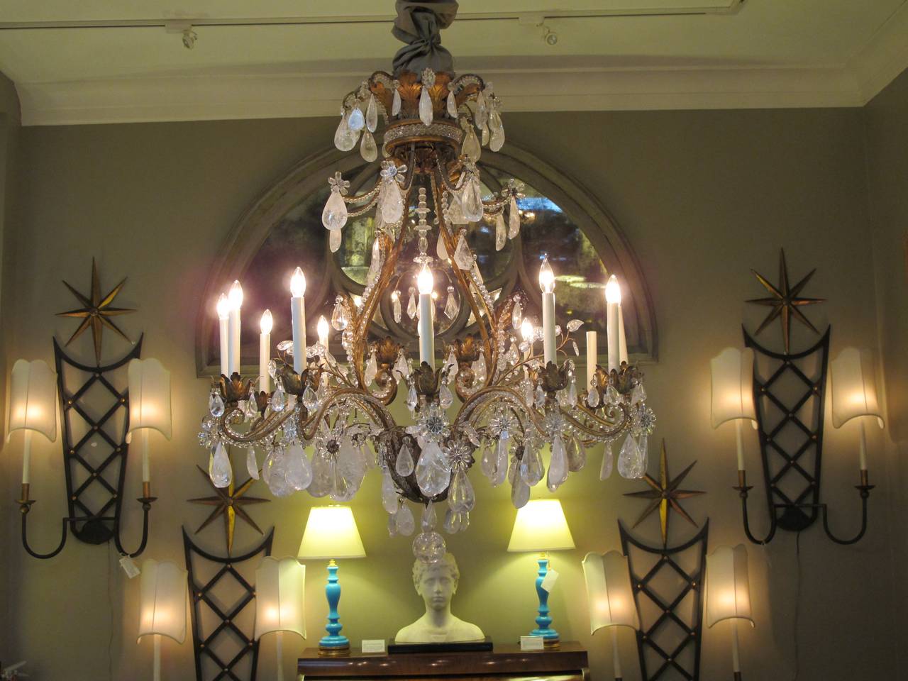 An exceptional French rococo style gilt-iron and tole rock crystal twelve-light chandelier by Nesle, Inc.; the large-scaled gilt-iron and tole chandelier emanating 12 scrolled beaded arms; adorned overall with robust rock crystal pendants and