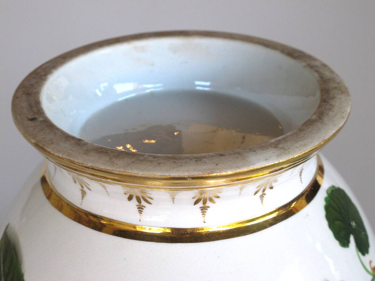 A good quality Paris porcelain polychromed double-handled cache pot or jardiniere; the cup-shaped bowl raised on a flared foot; with a hand-painted band of floral stems and fruit with gilt highlights.