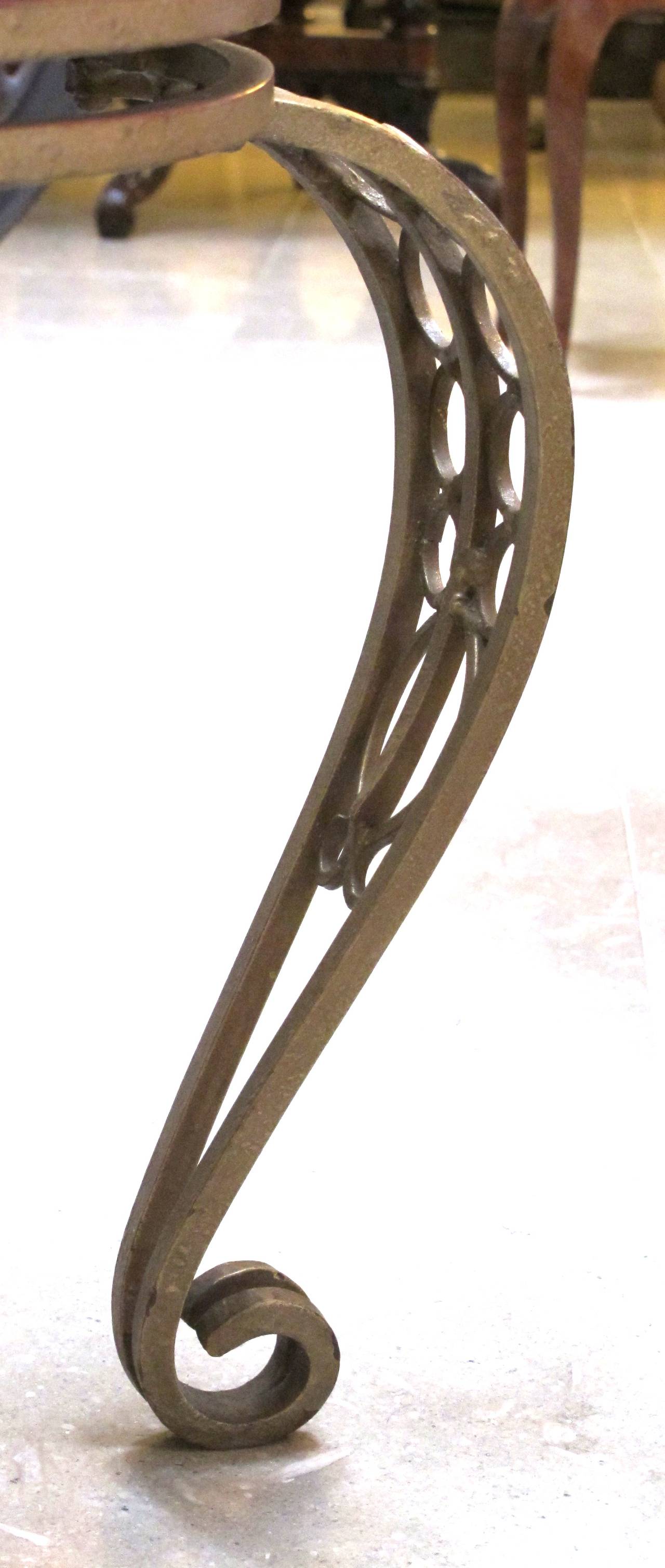 A shapely French Art Deco gilt iron circular table with mirrored top; the original mirrored top above an openwork frieze on exaggerated openwork cabriole supports.