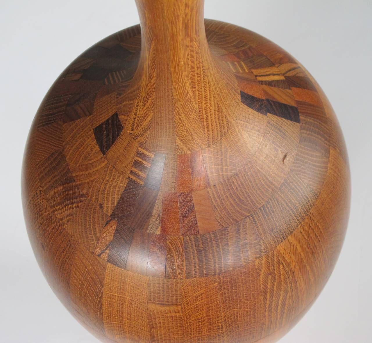 A large-scaled and well-executed French Mid-Century laminated and turned wooden urn; the slender flaring neck above an ovoid body; composed of various laminated wooden sections turned on a lathe.
