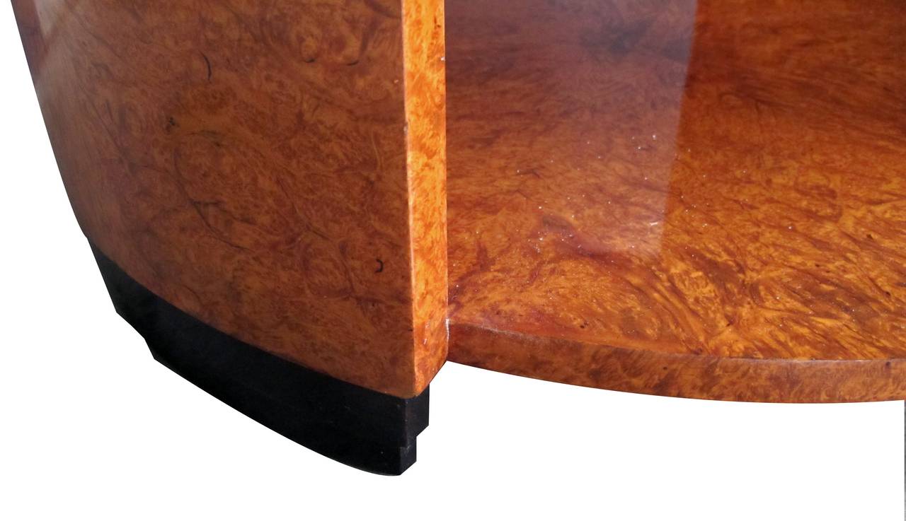 A richly patinated French Art Deco burl-elm wood matchbook-veneered circular side or center table; the well-figured top above curved sides joined by a lower shelf.