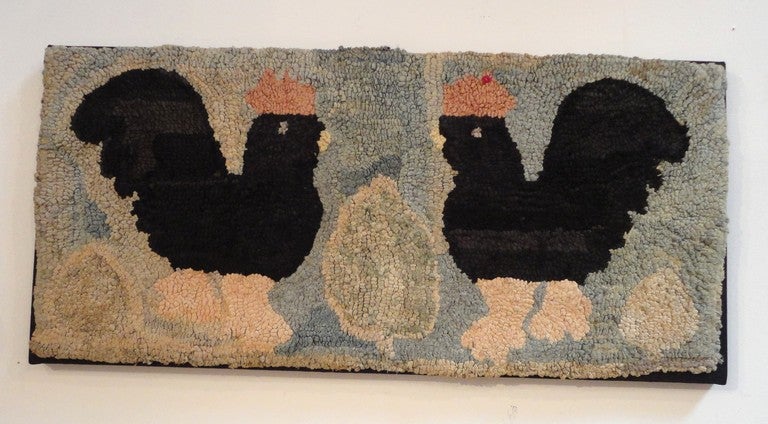 Wonderful hand-hooked rug of two chickens on a blue ground sewn on black linen and mounted on board. This amazing folky rug was found in Centre County, Pennsylvania. It is in great condition with light discoloration from age.