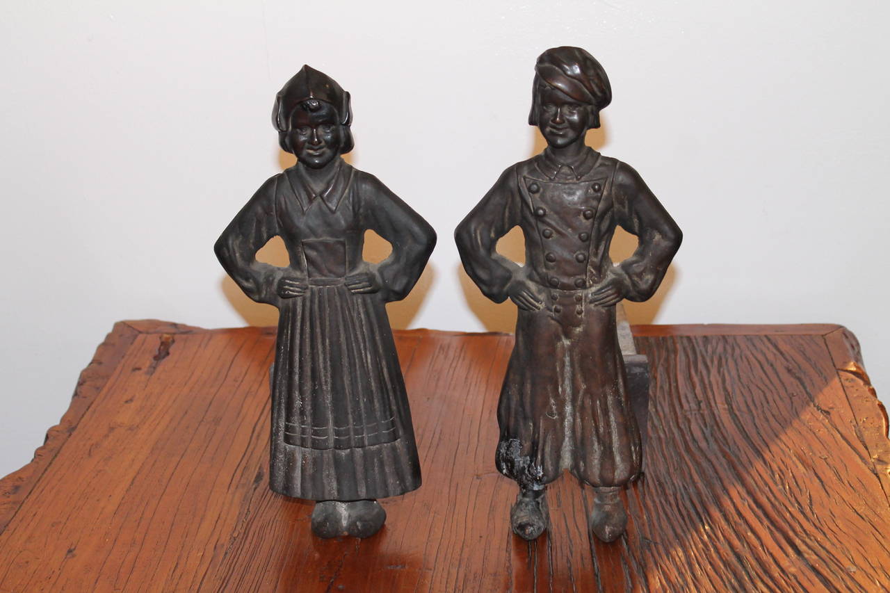 This pair of andirons were made by Sheffield Andirons in Sheffield, New York. These fun figural andirons have a wonderful worn patina. The condition are very good with wear consistent with age and use. These were made in the 1930's. Minor wear from