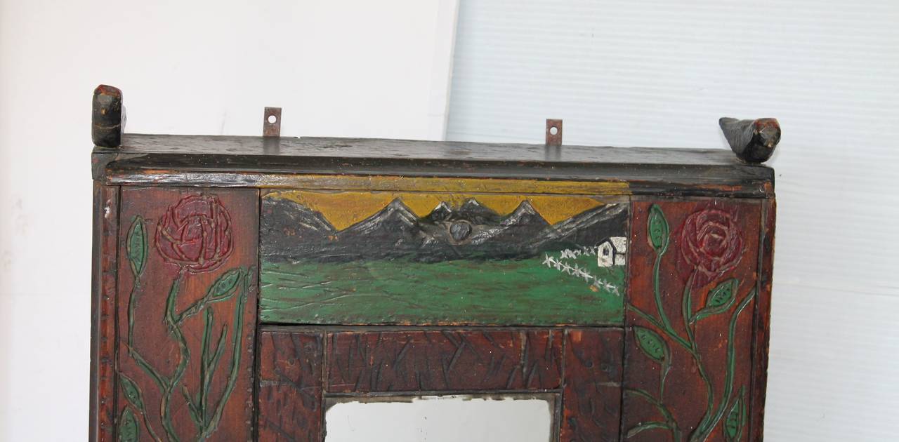 This is so fantastic with deep carving of roses on the side panels and mountains on the top panel with the house on the hill. On the top on both the left and right side are hand-carved and painted birds. The entire cabinet is also chip carved and