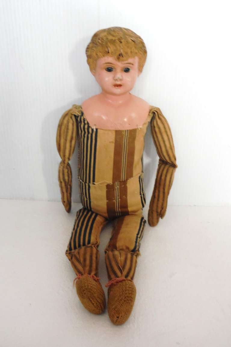 This folky signed Minerva doll has a hand sewn ticking fabric body and original painted tin head .The condition is very good .