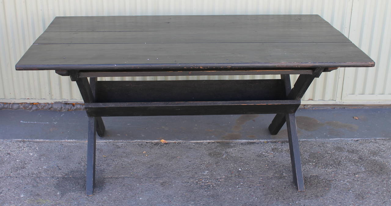 Wonderful simple form black painted sawbuck table from New England. The condition is very good and sturdy with a wonderful patina. This is a very good size and seats 4-6 people .