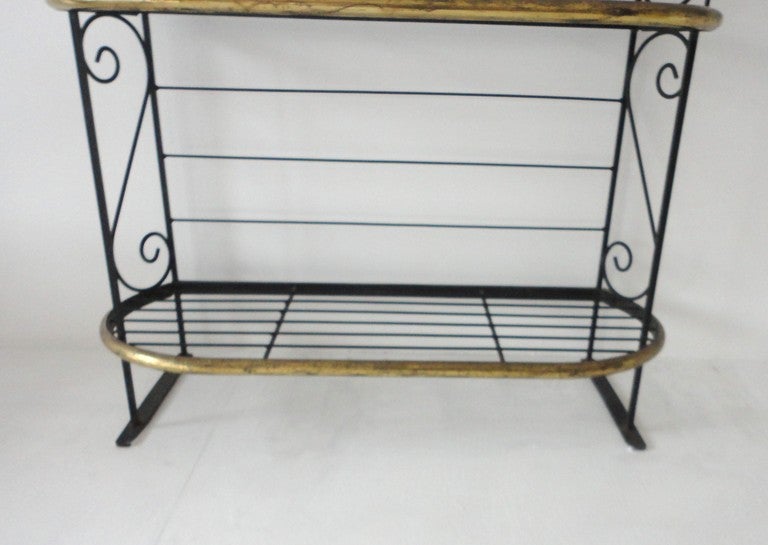 Early iron and brass trim bakers rack.This wonderful ,sturdy shelf works great for display in a store or restaurant .The shelf would house towels in a large bathroom too.The condition is very good.