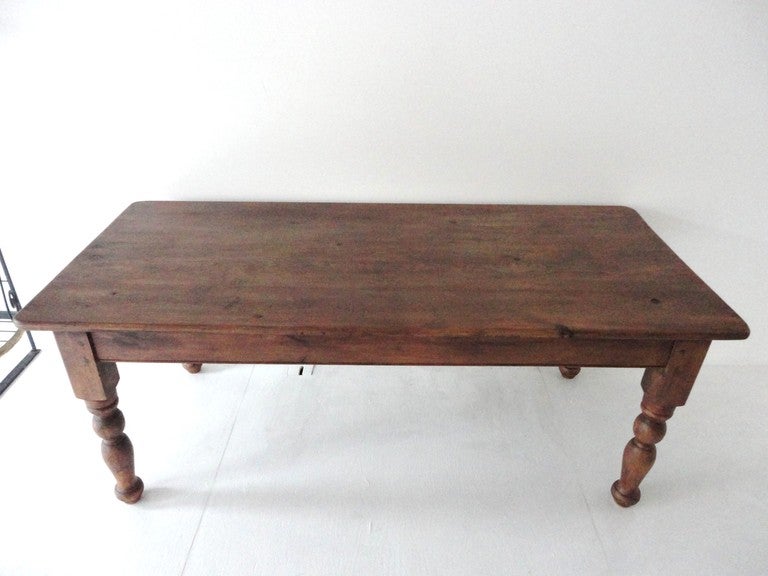 Fantastic 19thc  simple turned leg large farm table from the mid west.This farm table sits 6-8 people very comfortably  .The construction is peg and cut nails with a very simple form. The finish is a old stain but dry surface.The patina is the very