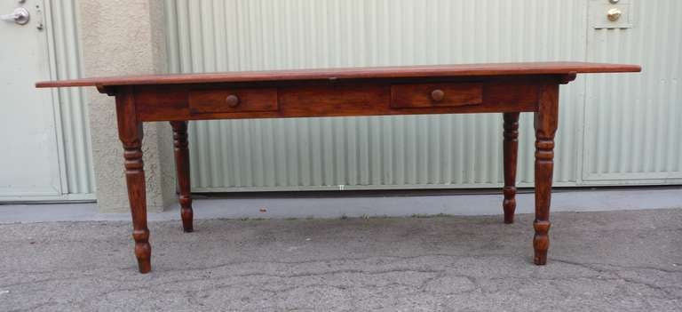 This very large 19thc New England lift top farm table has two drawers in the base with an extremely well constructed lift top. Great for large gatherings or entertaining dinners; easily seats 12 -14 people. This pine table has a wonderful old stain