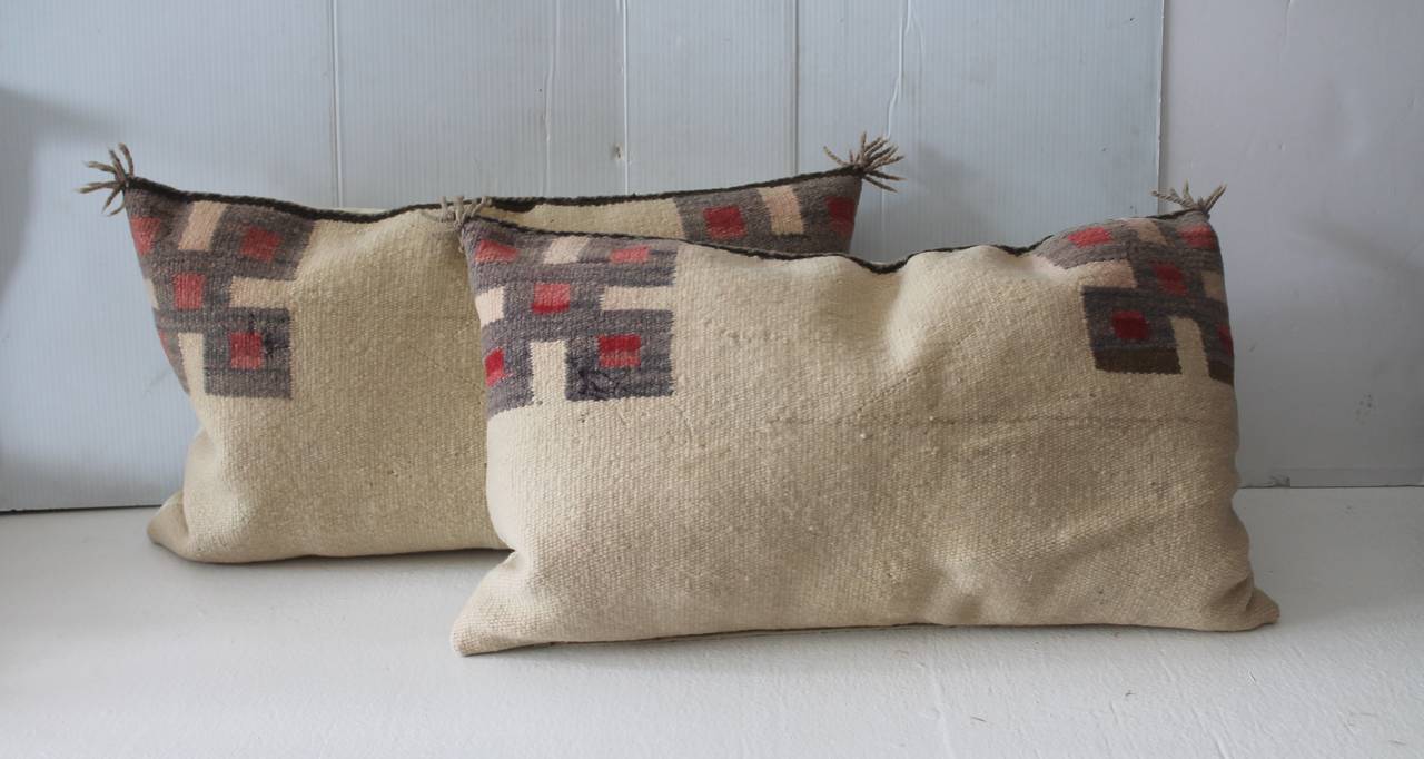 This is a most unusual pair of simple, yet wonderful geometric Navajo Indian weaving saddle blanket pillows. The early ties in the top corners are original to the weaving. The backing is in a natural linen. Sold as a pair.