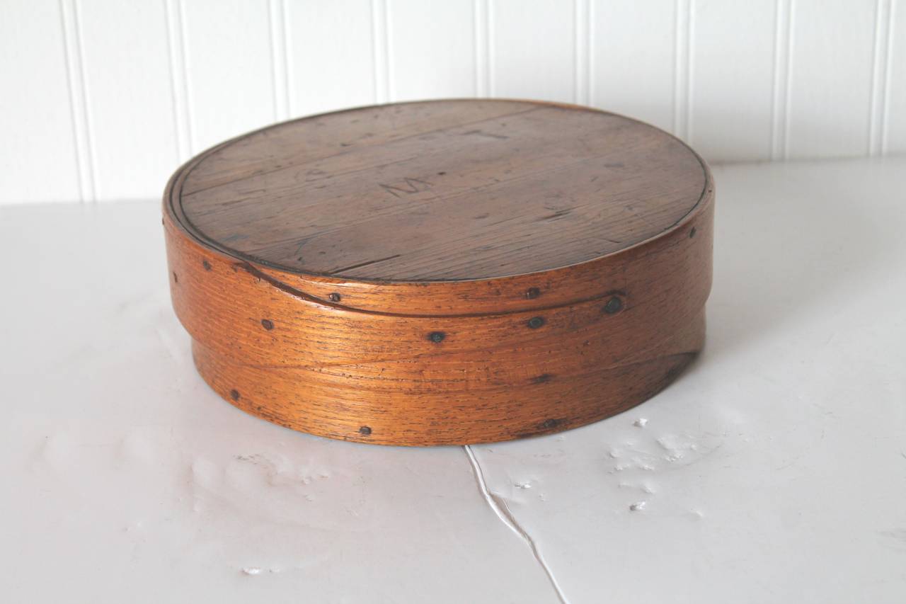 This is a large 19th century Shaker pantry box found in New Hampshire. It has the large exaggerated fingers or bands with handmade rose head nails and wood peg construction. This is quite unusual to find this size and shape. Condition is very good