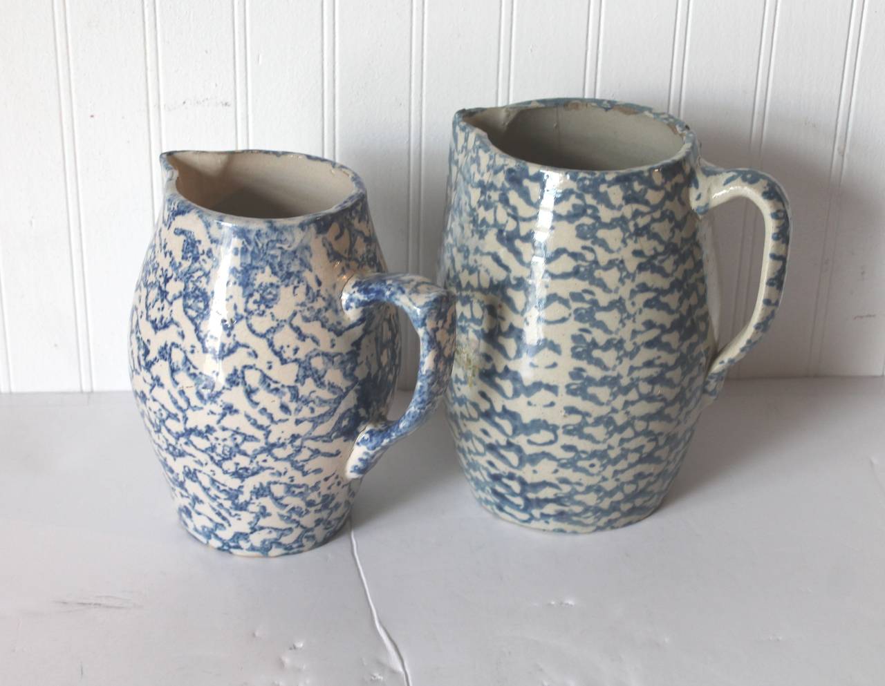 These two design sponge pitchers have that barrel form and both are slightly different in form and shape. We are selling them as a group. They both have unglazed bases or bottoms. The larger one is 81/2