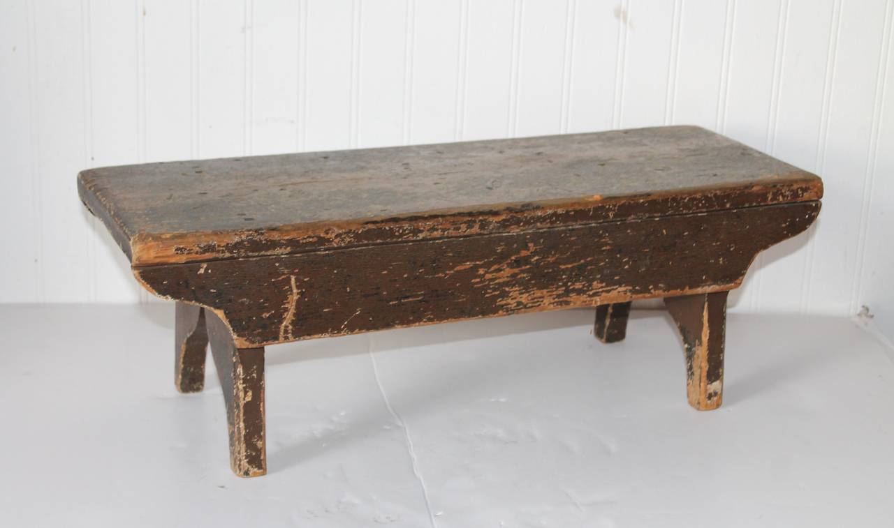 This early worn brown painted 19th century bench was found in New England and has great cut-out. The condition is very good with a great old patina.