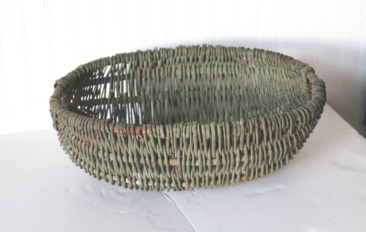 This handmade and original painted sage green basket was found in New England and in good condition. This double handled basket looks like a gathering basket. Great for a collection of stone or velvet fruit. Fantastic old surface and condition.