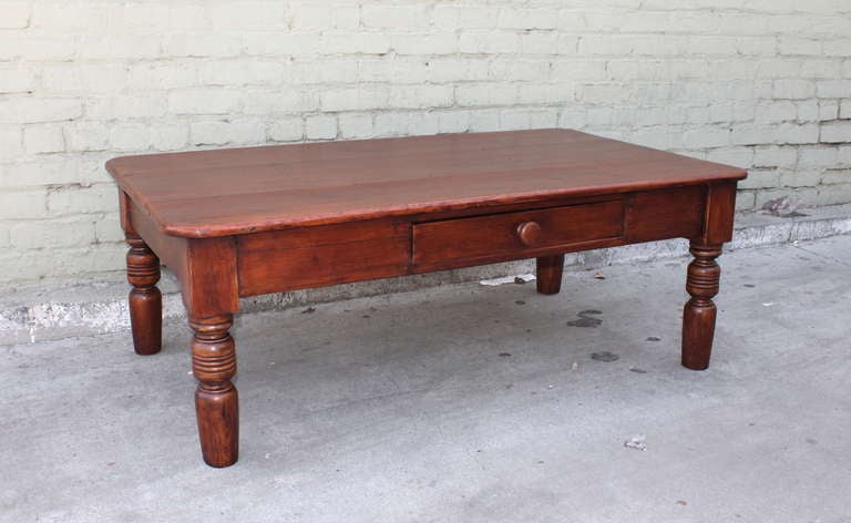 This folky New England turned leg farm table has a wonderful plank top and thick, chunky legs . The drawer in the front is original and dovetailed construction . This was a full  size farm table at one time , cut down to a amazing coffee table. It