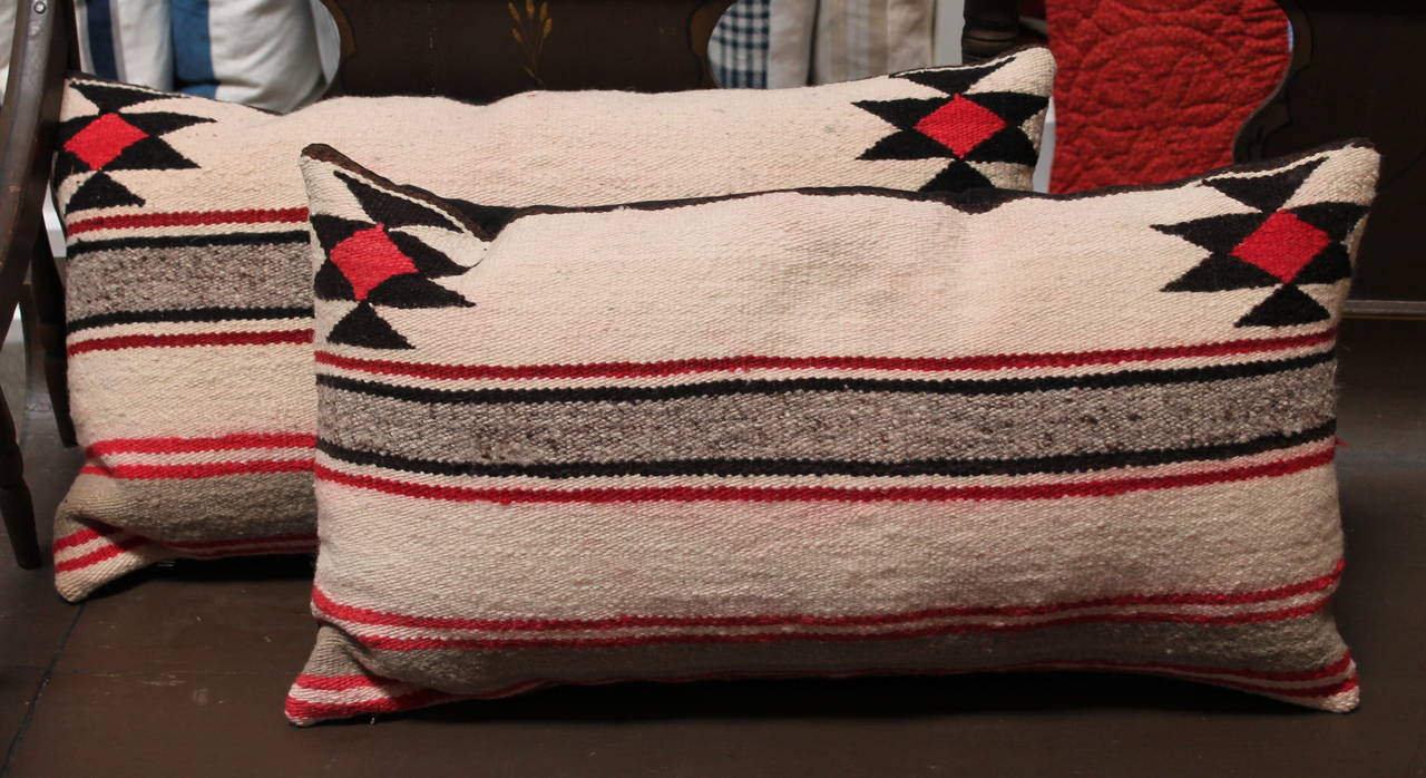 Simple geometric saddle blanket weaving pillows with stars in corners. Sold as a pair. The condition is very good with minor bleeding in the cream band section. The backing is in a black cotton linen. Inserts are down and feather fill.
