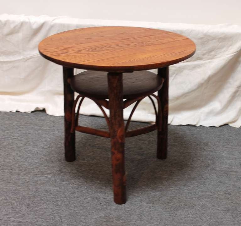 From the Old Hickory Furniture Company of Martinsville Indiana, this charming twig, oak and hickory sapling occasional table is perfect for either indoor or outdoor use.  The table stands 28 inches in height and 30 inches in diameter.  Outstanding