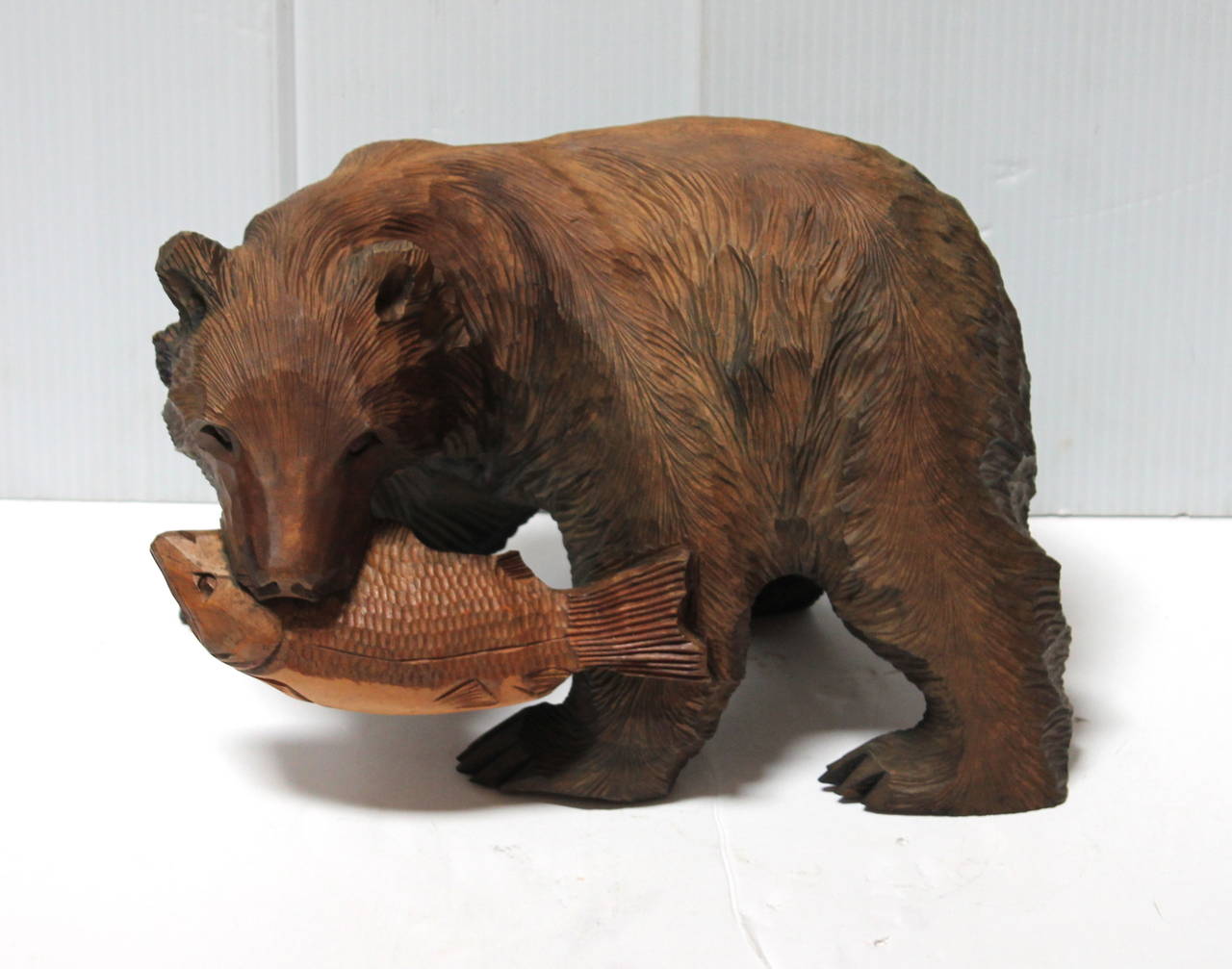 wooden bear with fish in mouth