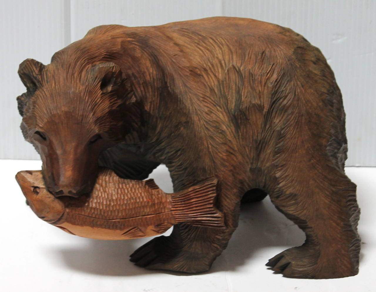 This folky hand-carved and painted bear with a fish in its mouth was found in Maine. The condition is very good.