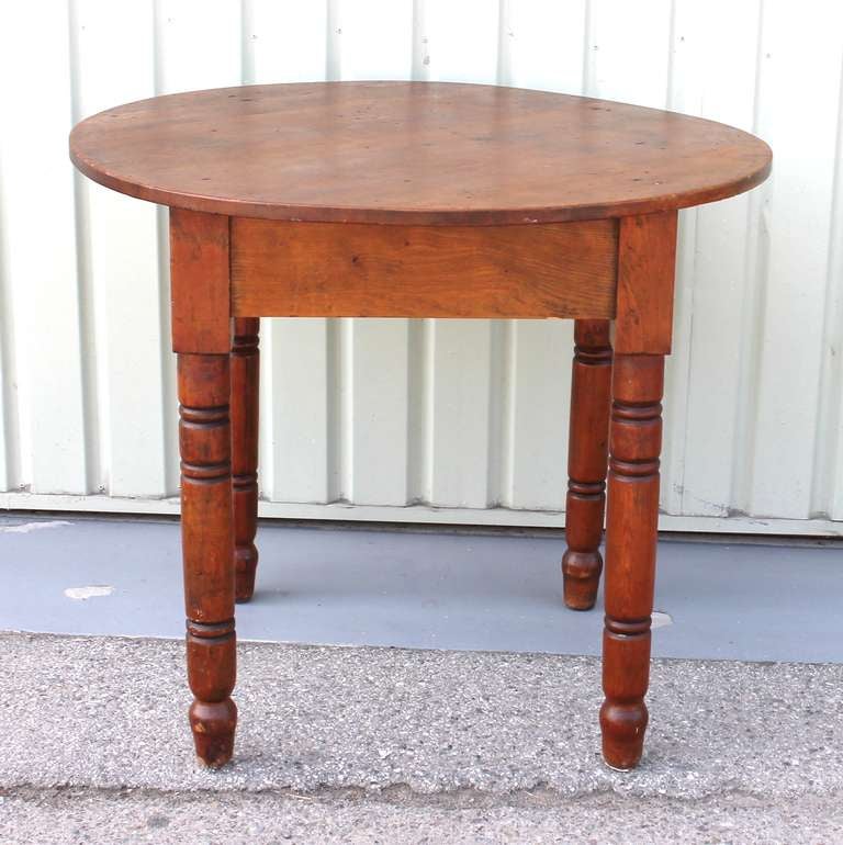 This early pine New England round tavern table has a super patina and in very sturdy condition . The table is constructed of square nails and retains all the original early wood blocks . The turned legs are quite simple and the table  has a great 