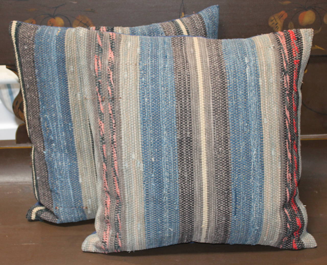 Pair of American Rag Rug pillows in country colors. The backing on these rug pillows are in a indigo blue cotton linen. Sold as a pair.