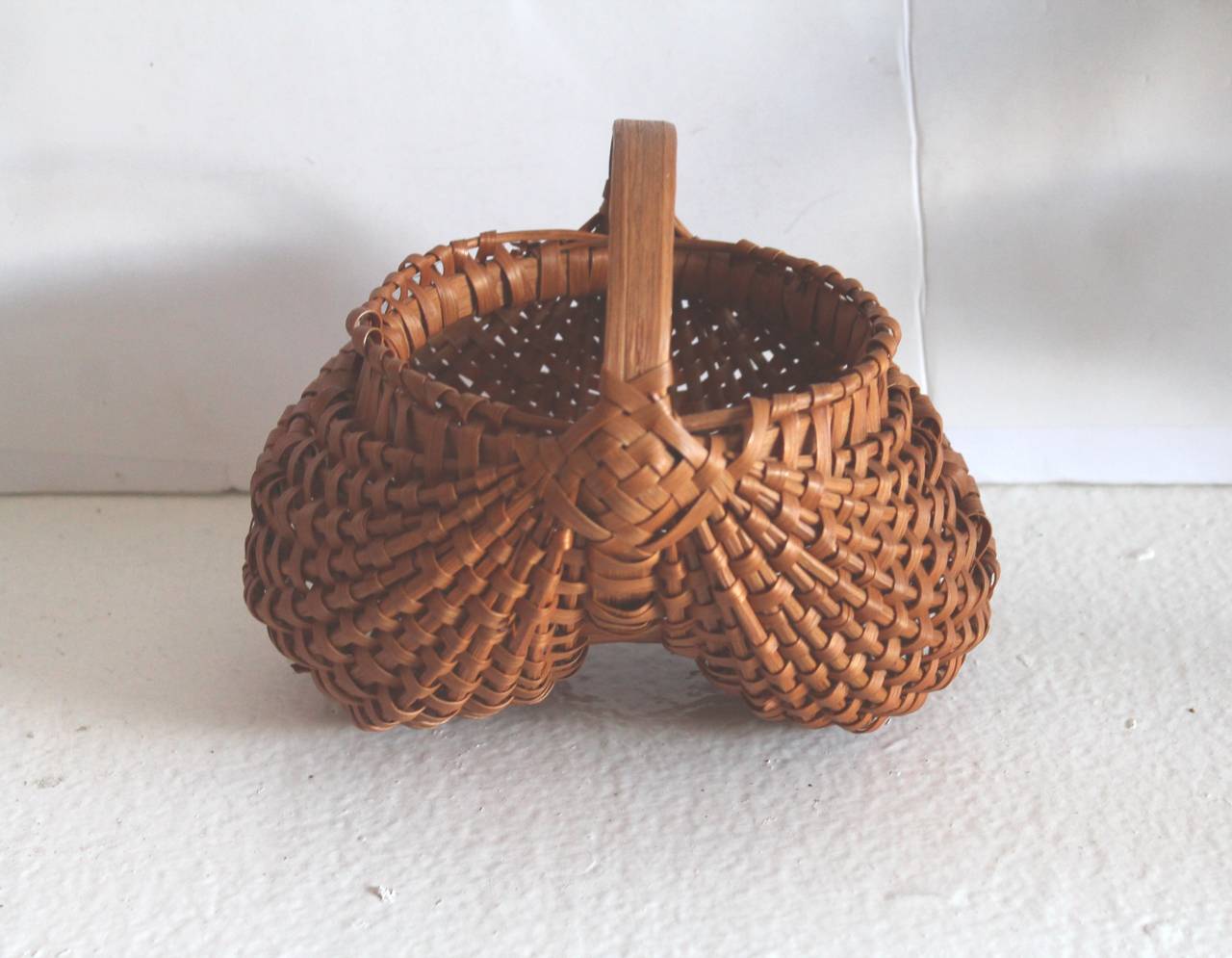 This wonderful buttocks basket has such great form and condition. The dry surface is nice and untouched. This baskets fits in the palm of your hands. This is a handmade basket.