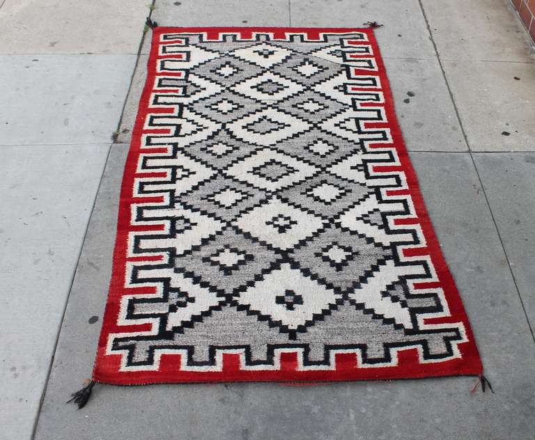 This geometric eye dazzler  & hand woven Navajo weaving runner is in very good condition and has the original corner ties . It is very clean with minor lighting in spots .  It does not detract from the design nor the condition  of this rug . The