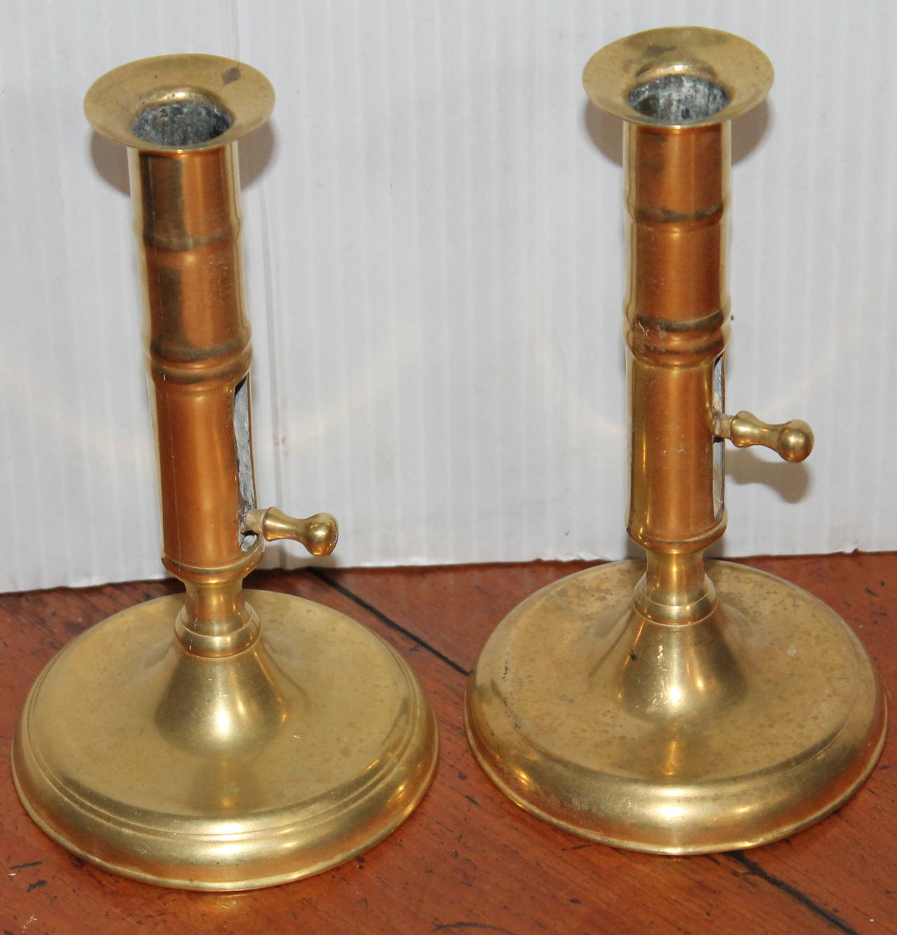This is an amazing pair of 18th century brass push up candlestick holders from England. This is most unusual finding a matching pair of this particular form.