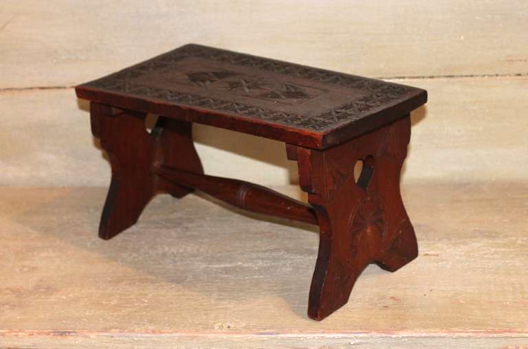This exceptional handcrafted and carved walnut presentation stool was acquired from an estate in Maine.  An outstanding example of early Americana craftsmanship, this piece shows extensive detail, including heart cut outs on both sides of the
