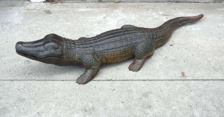 This fantastic large cast iron alligator has a wonderful original painted body showing an exceptional worn patina. The belly paint gradates from dark green to mustard and the top surface of this cast iron creature shows worn dark original green