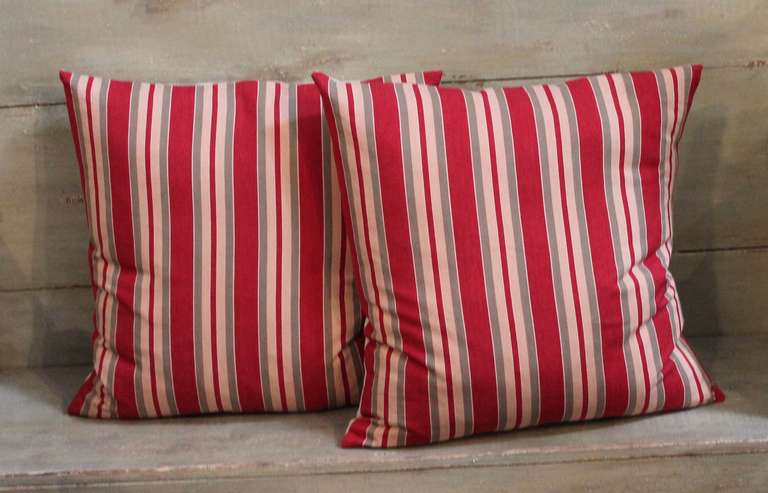 This pair of red, tan and gray pillows are made from 19th century ticking and are in pristine condition showing exceptionally vibrant colors. Down and feather fill with zipper closures. The backings are in a raw linen.