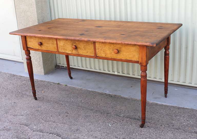 This early 19th century New England farm table shows an exceptional original surface with outstanding patina.  The table has three drawers with dovetailed construction and turned legs.  Classic form, this table would make a terrific over-sized
