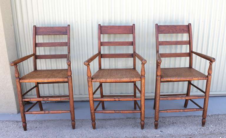 This set of three handcrafted slatted high back bar stools are solidly constructed with oak showing a warm and rich chestnut stained finish.  The seats are a double woven rattan and are remarkably comfortable, durable and sturdy.  Would be a great
