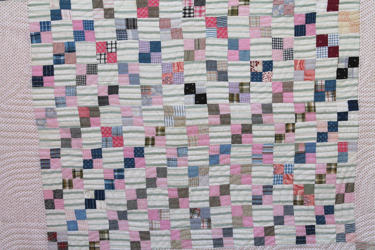 This is a very pleasant pastel nine patch quilt. It is a multi calico prints of many different varieties. Condition is very good. The piece work is very good. The quilting is done in a clamshell format.