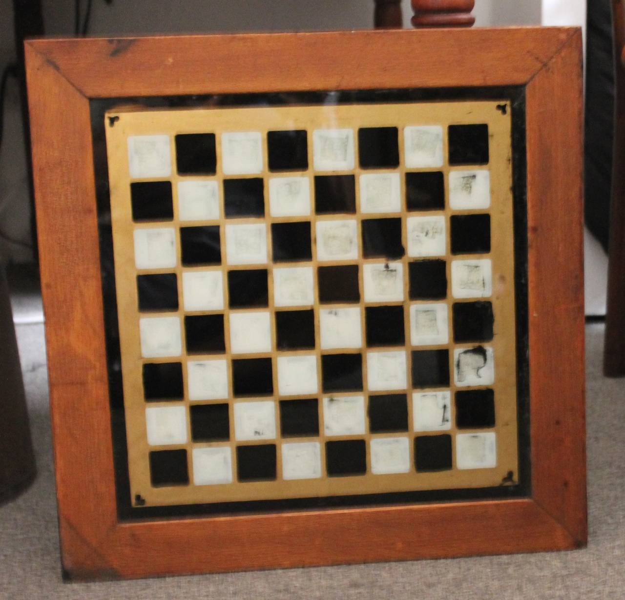 This amazing 19th century reverse painted gameboard is stamped Arkansas and retains its original painted frame. The back is painted black and wired for hanging. The board is painted black and white with old gilding and gold hearts in each corner.