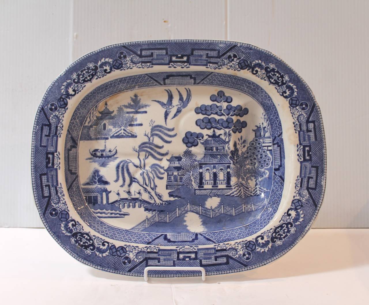 This is quite unusual to find the blue willow serving meat platter with a indent drain for the meat juice. This early 19th century blue willow ironstone platter is in great condition. This is stamped Ridgeway, England.