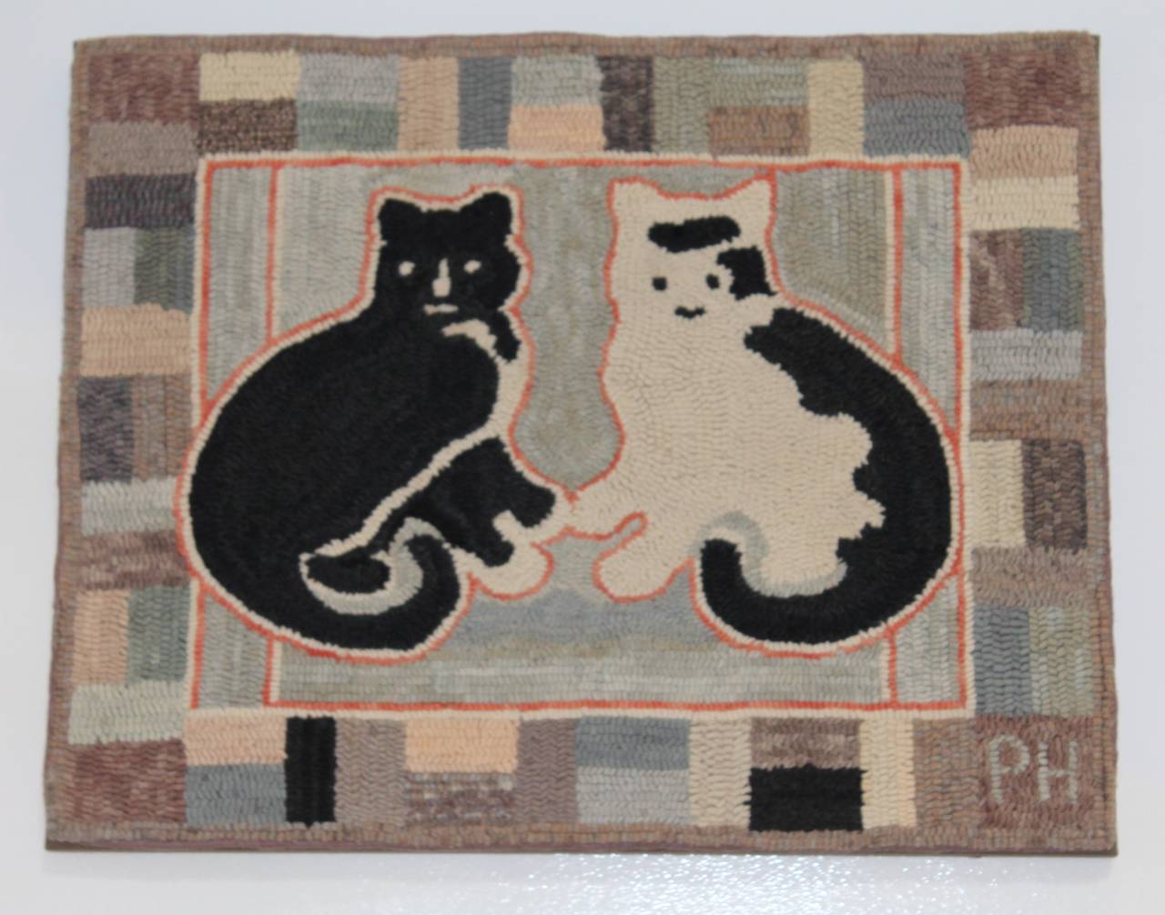 This fun folky hand-hooked pictorial rug was proof mounted and cleaned. This whimsical rug was hooked in calm primary cool light colors. The lower left hand corner the hooker signed her initials PH. We think perhaps it is a male and female cats. The