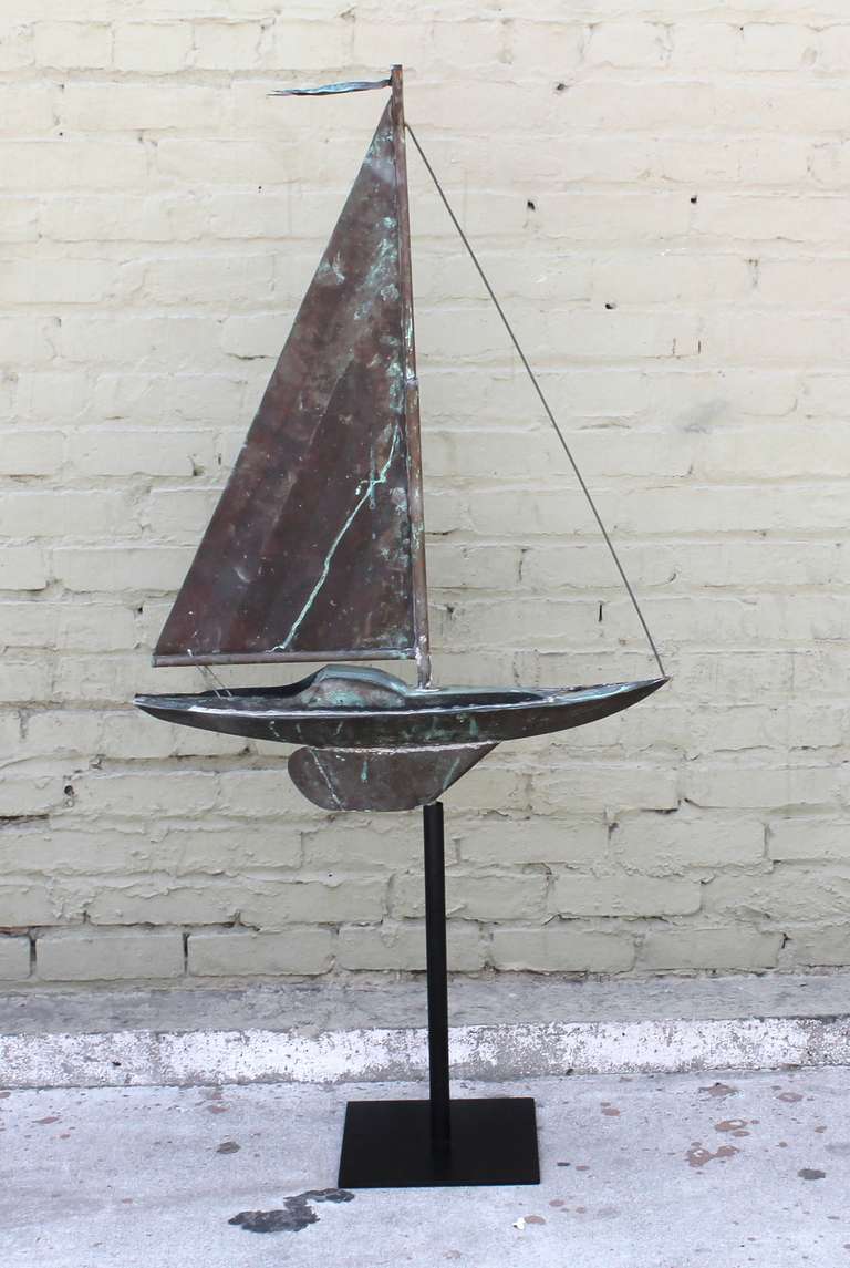 This beautifully hand crafted, full bodied, 19th century New England copper weather vane is fashioned in the shape of a sailing boat and demonstrates masterful artisanship in its construction.  The sail has rippled folds in the copper creating the