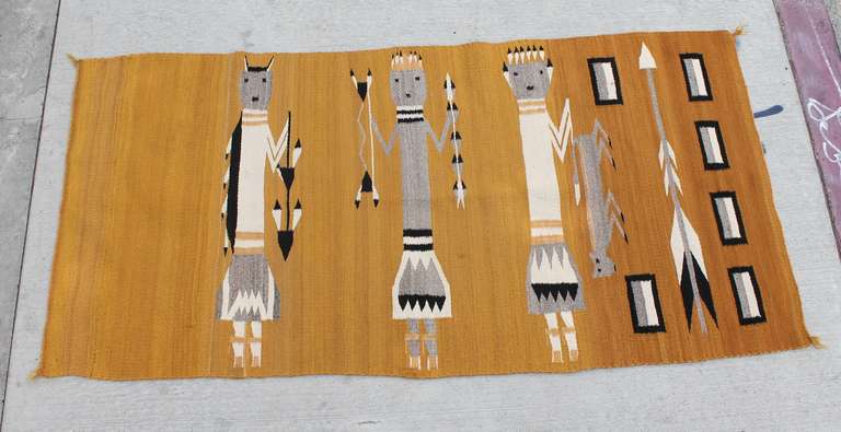 This Navajo weaving features the classical symmetric line of Yei with arrow symbols.  However, what is unusual about this piece is that the third Yei in this weaving is holding an animal with the first Yei in an animal mask.  Highly unusual! 