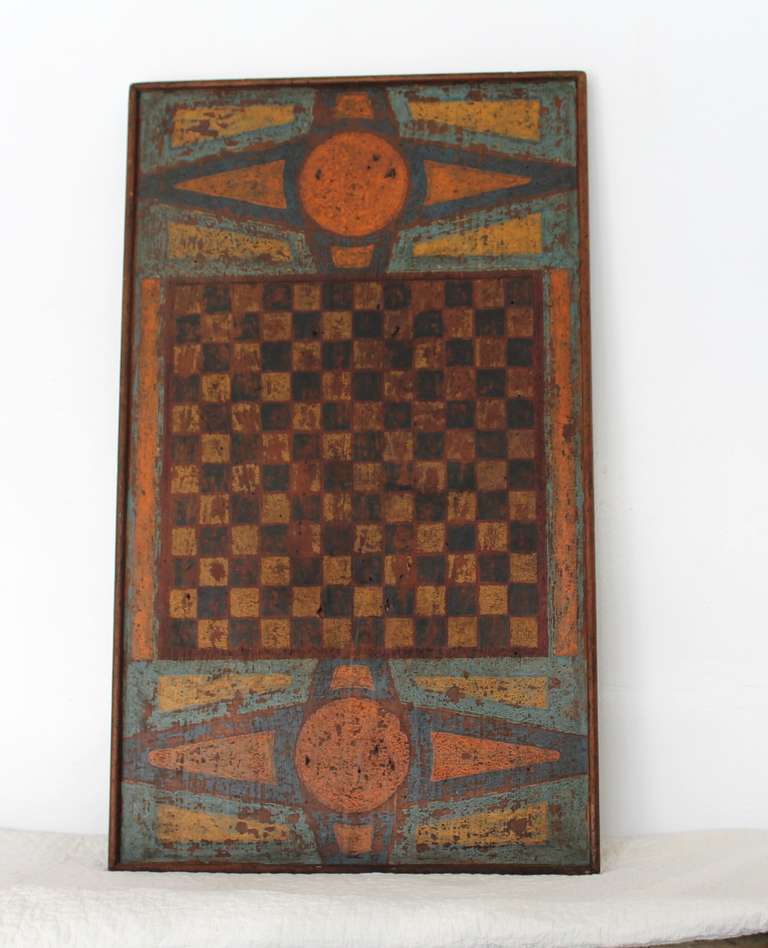 This exceptionally rare 19th century original painted Canadian game board is one of the finest we’ve seen within the genre.  This piece shows an exquisite polychromatic original painted wood surface with Parcheesi on one side and a classic