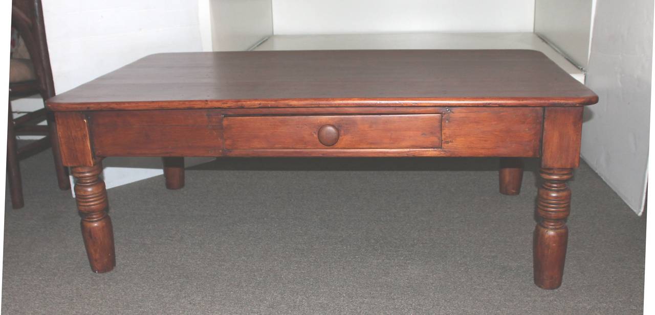 This amazing early pine coffee table has the original drawer and thick turned legs. Many years ago it was a kitchen farm or work table with a amazing untouched surface. The greatest patina of all. Square nail and wood peg construction. The center