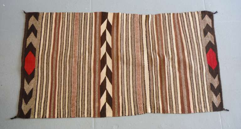 This Navajo Indian Chinle Double Sided Saddle Blanket shows multi-tonal tightly woven bands in shades of brown, cream and gray.  This effect was produced through the alternating of several different colors in the strands of the weft (transverse